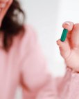 Woman Taking CBD Capsules with Added Nutrients