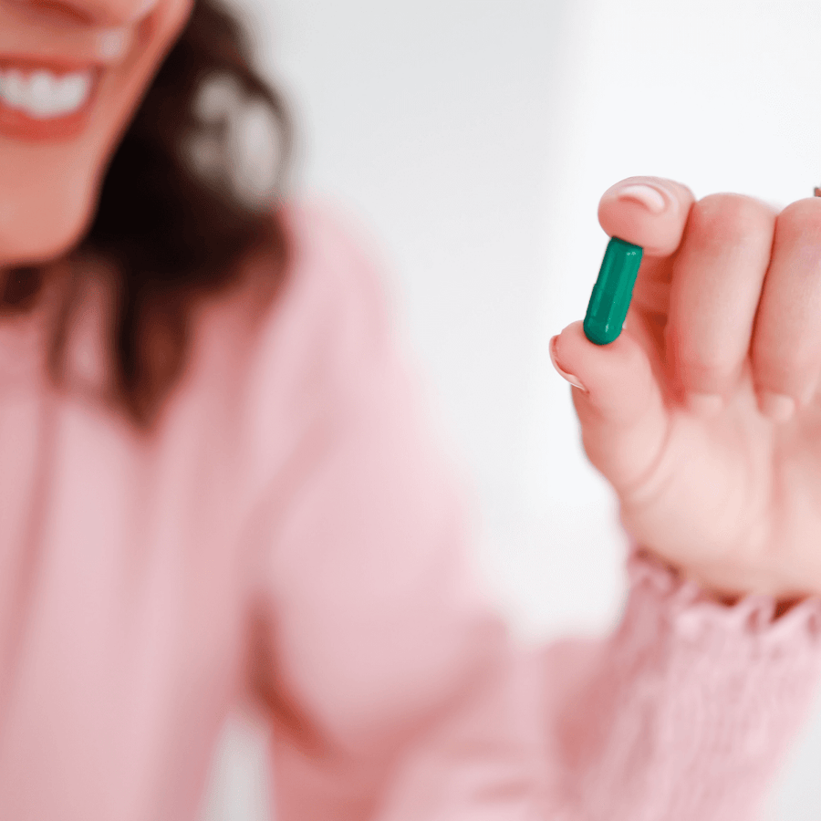 Woman Taking CBD Capsules with Added Nutrients